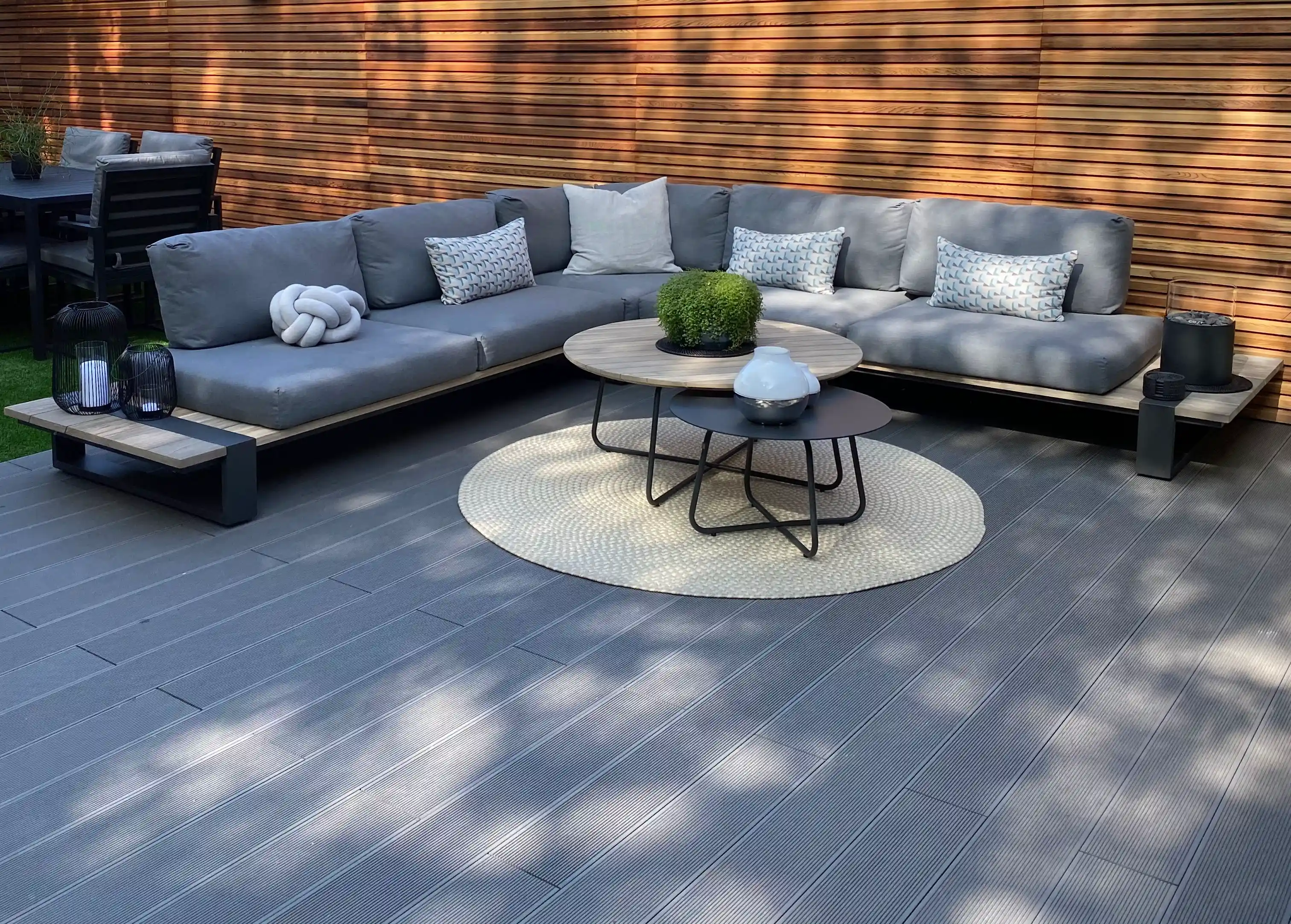 Composite decking and outdoor seating beside timber fencing