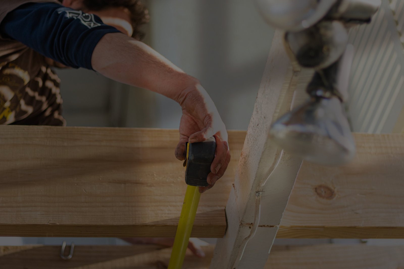 Evolve Outdoors installer measuring timber during an outdoor living project