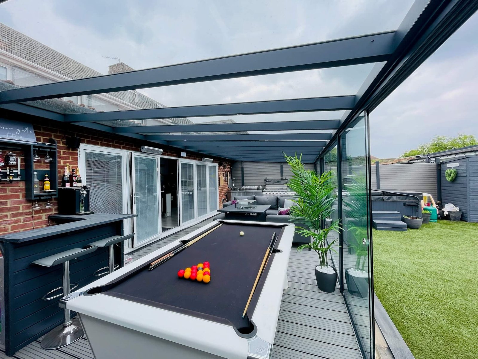 Anthracite grey glass room with outdoor bar and pool table