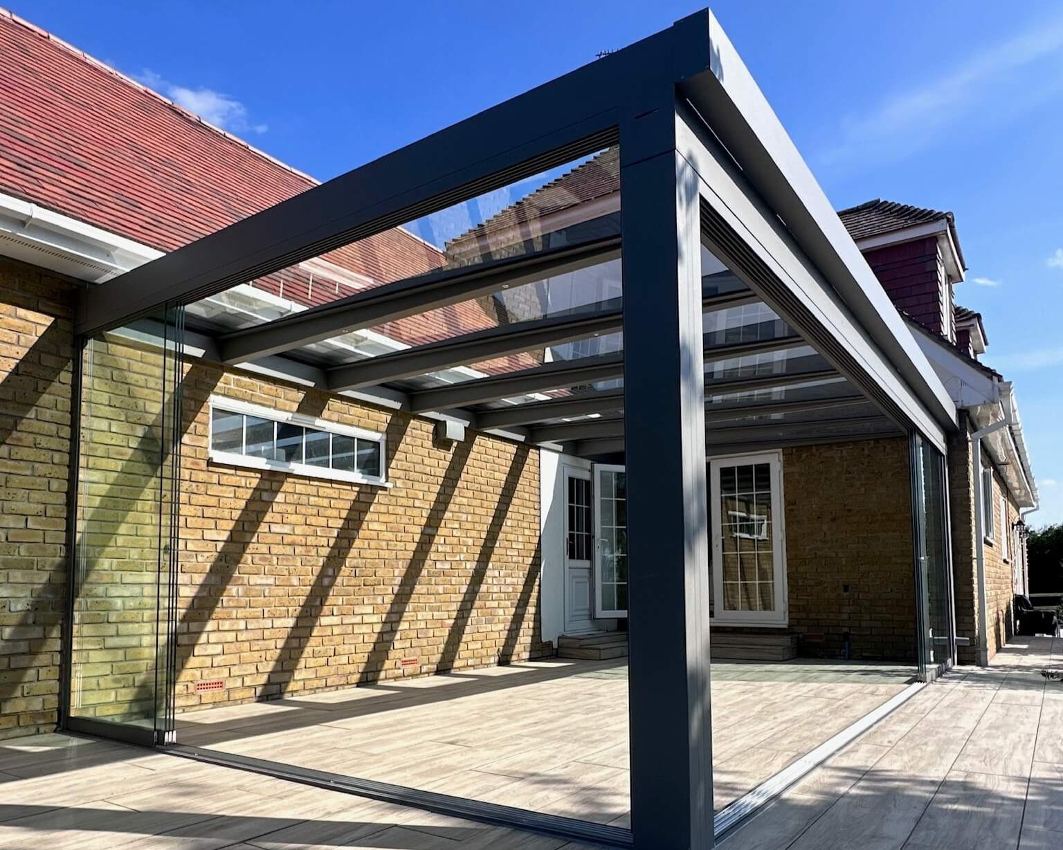 Anthracite grey glass room veranda beside a brick house