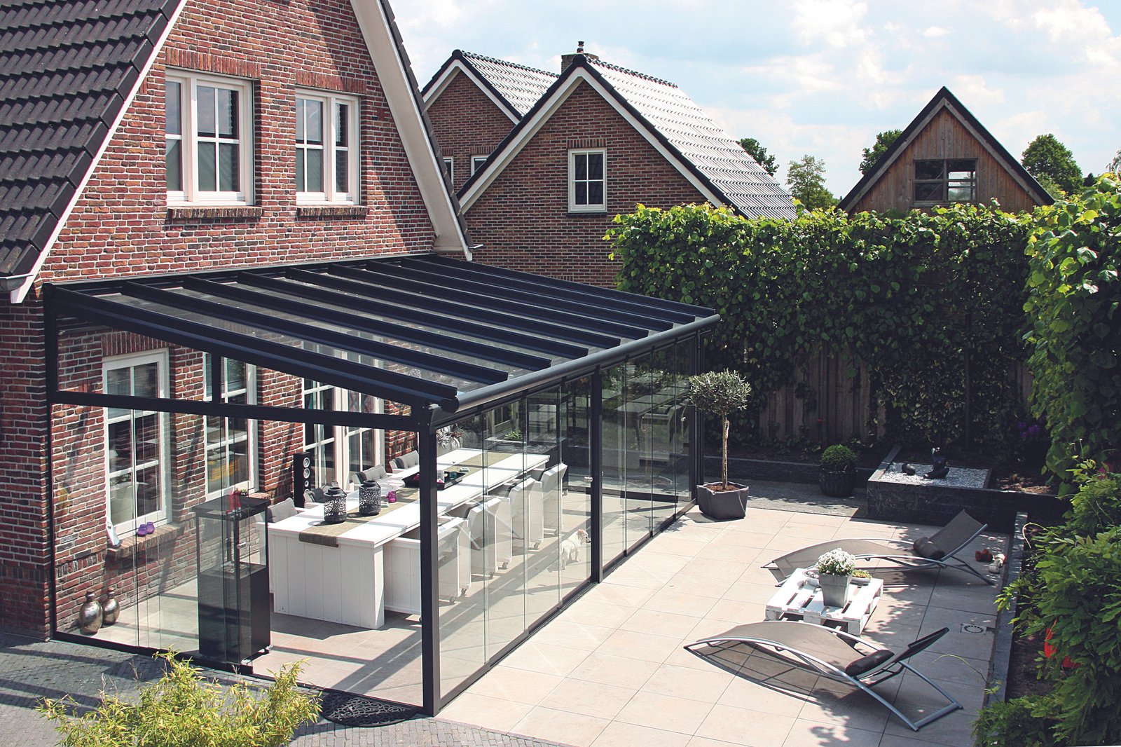 Aluminium glass veranda connected to a home and garden seating area